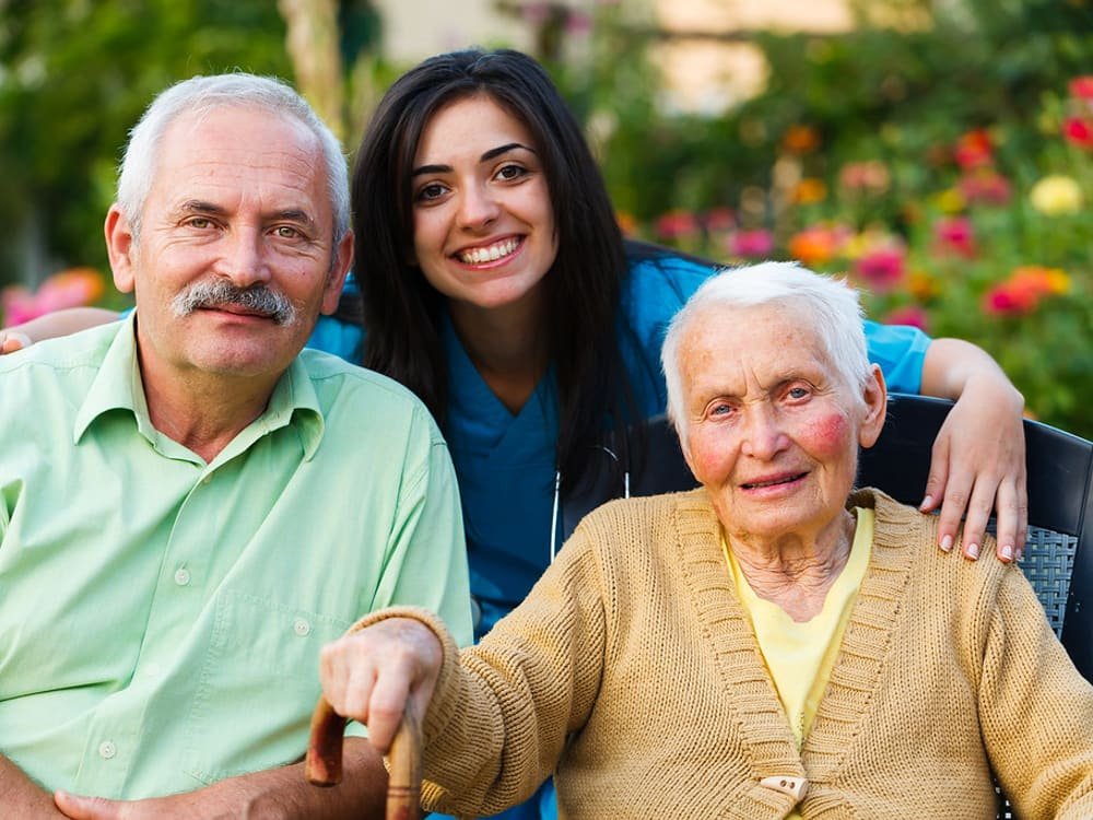 A home-care nurse spending time with an elderly patient and family member